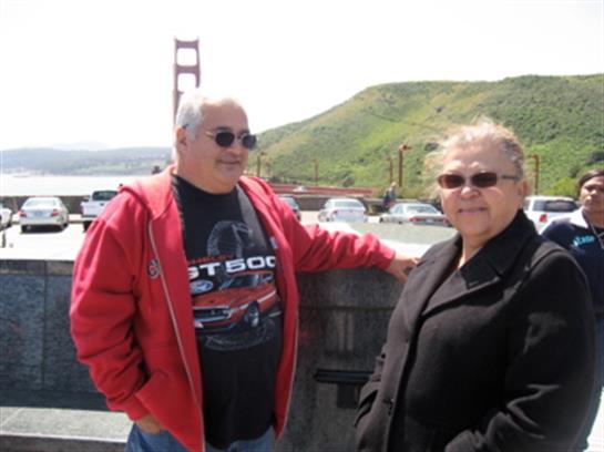 Couple enjoys a moment together at a scenic lookout with the Golden Gate Bridge behind them.
