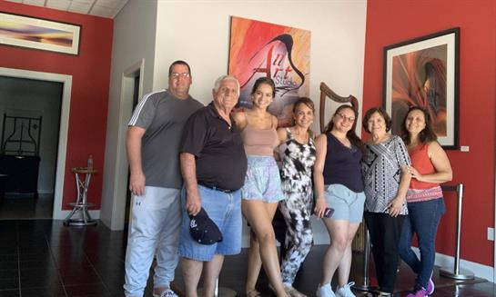 A cheerful family poses together in a cozy living room filled with colorful decor.
