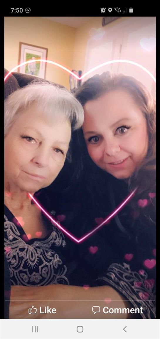 Two women share a warm embrace, smiling brightly while enjoying quality time together indoors.