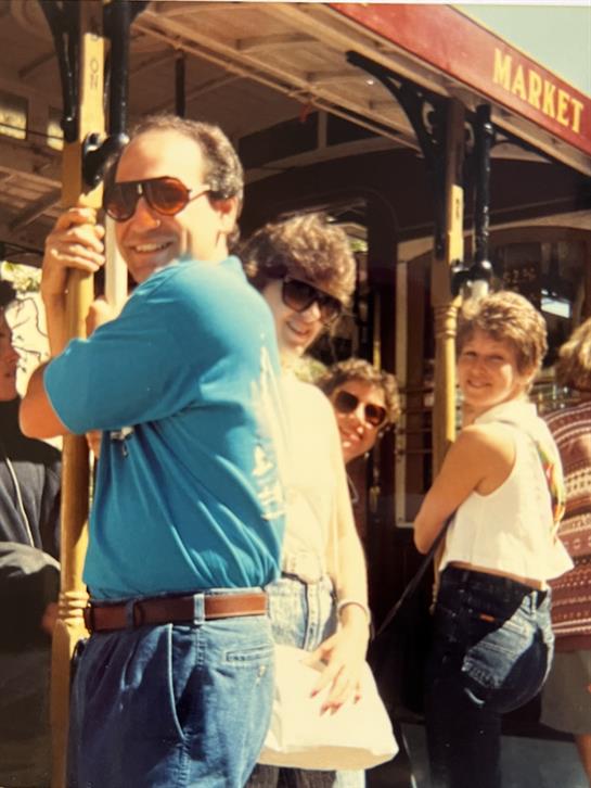Friends are having fun at a vintage carousel in a vibrant amusement park during summer.
