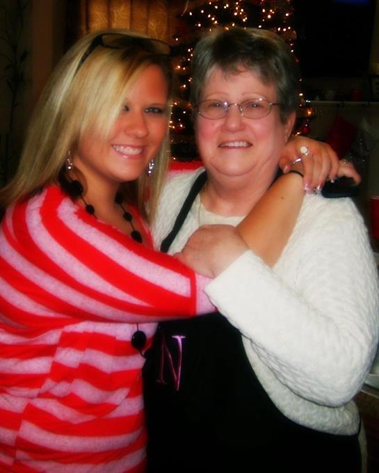 Two women embrace joyfully, celebrating together in a warm and inviting environment.