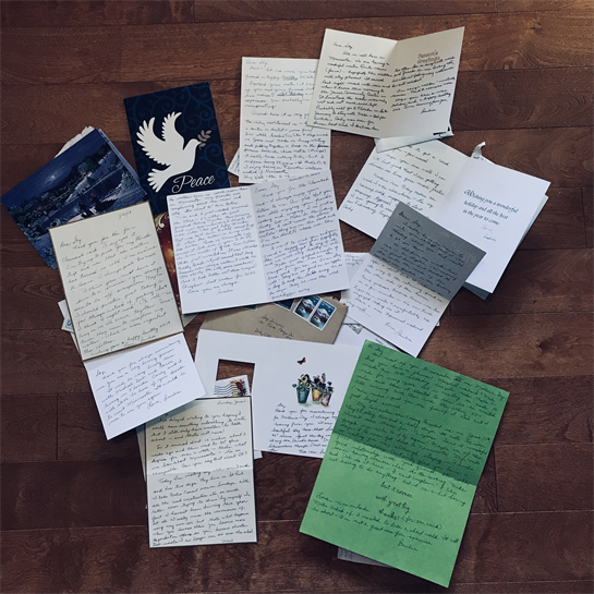 Handwritten letters displayed on a wooden floor, revealing heartfelt messages and memories.