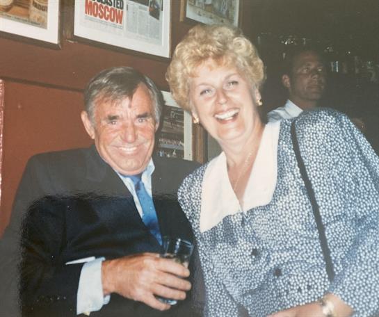 Two friends enjoy a joyful moment together while celebrating in a vibrant venue.