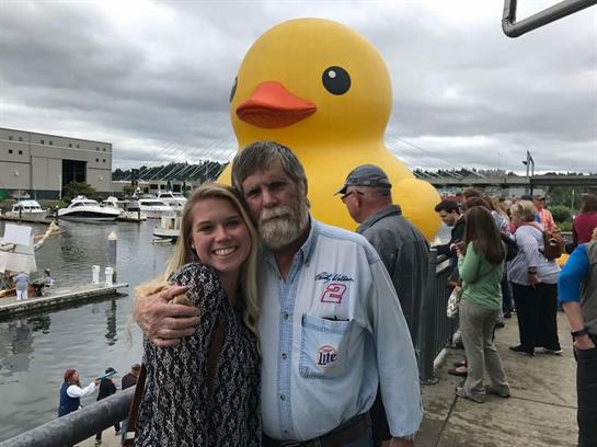 People gather by the waterfront to snap photos with a giant rubber duck and enjoy the festivities.