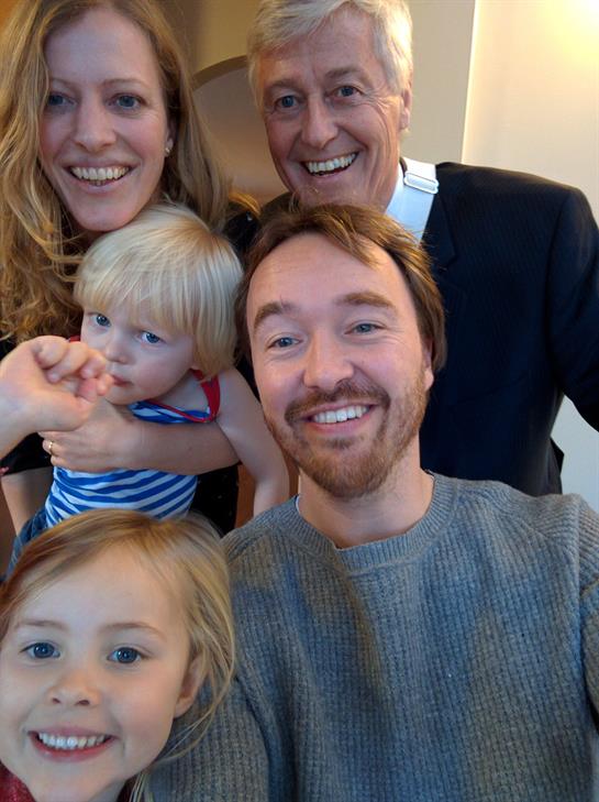 A happy family shares an afternoon of laughter and smiles in their cozy living room.