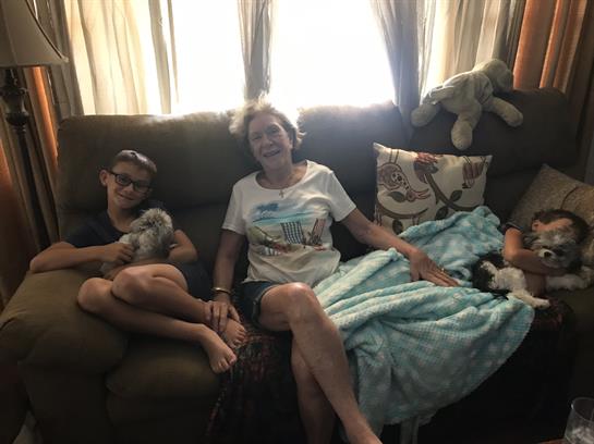 Family members enjoy a relaxed afternoon at home together on a comfy couch surrounded by warm light.