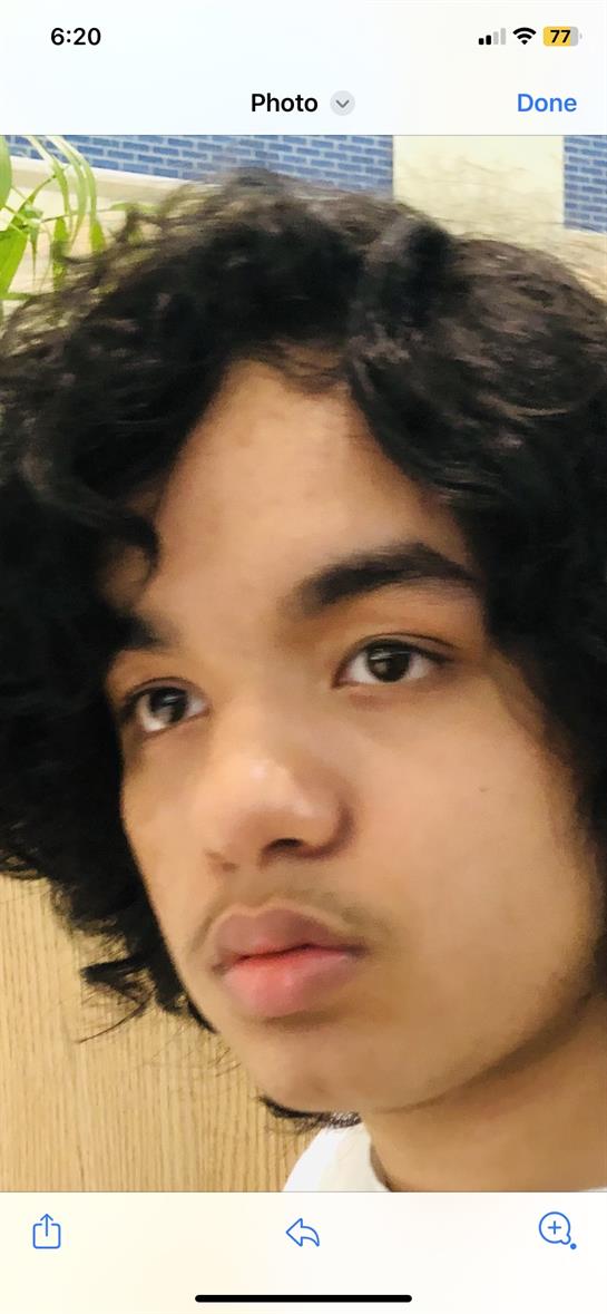 A young man with curly hair displays a serious expression, likely deep in thought or reflection.