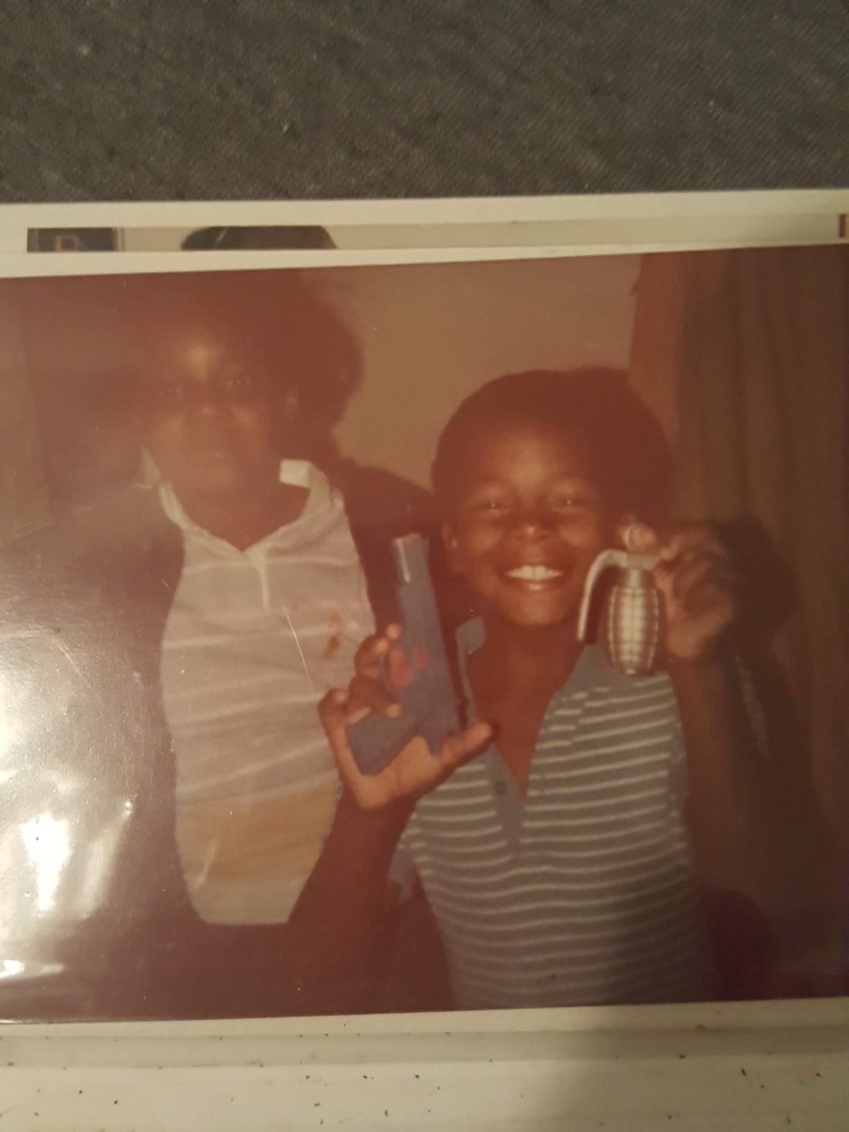 Two boys happily show off their vintage toys in a cozy 1980s-inspired room.
