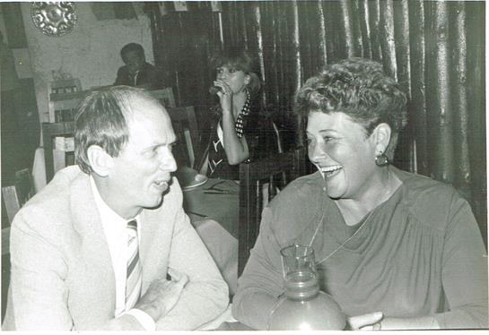Two people engage in lively conversation within a warm, inviting restaurant atmosphere.
