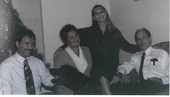 Four people share smiles and laughter in a warm and inviting living room environment.