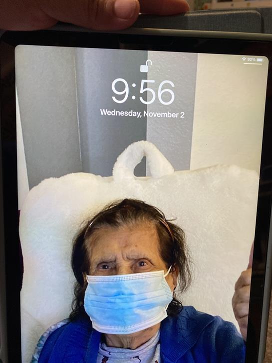 An elderly individual in a medical environment looks puzzled while wearing a blue mask.