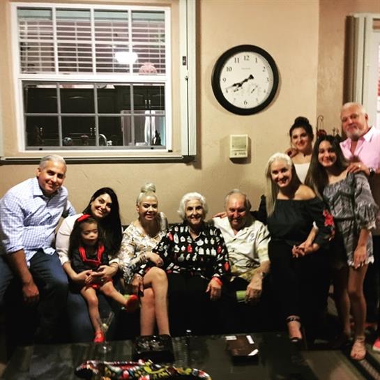 Family members share stories and laughter together in a cozy living room.