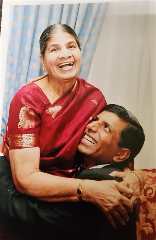 A mother and her son share a heartfelt moment of laughter and affection in their home.