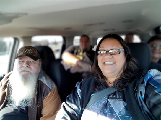 Lively friends are sharing smiles and laughter during a joyful car ride on a bright day.