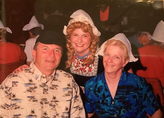 A joyful family poses together in traditional attire during a festive celebration at night.