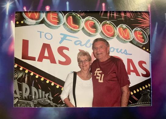 A couple poses joyfully in front of the famous Las Vegas sign, capturing a special vacation memory.
