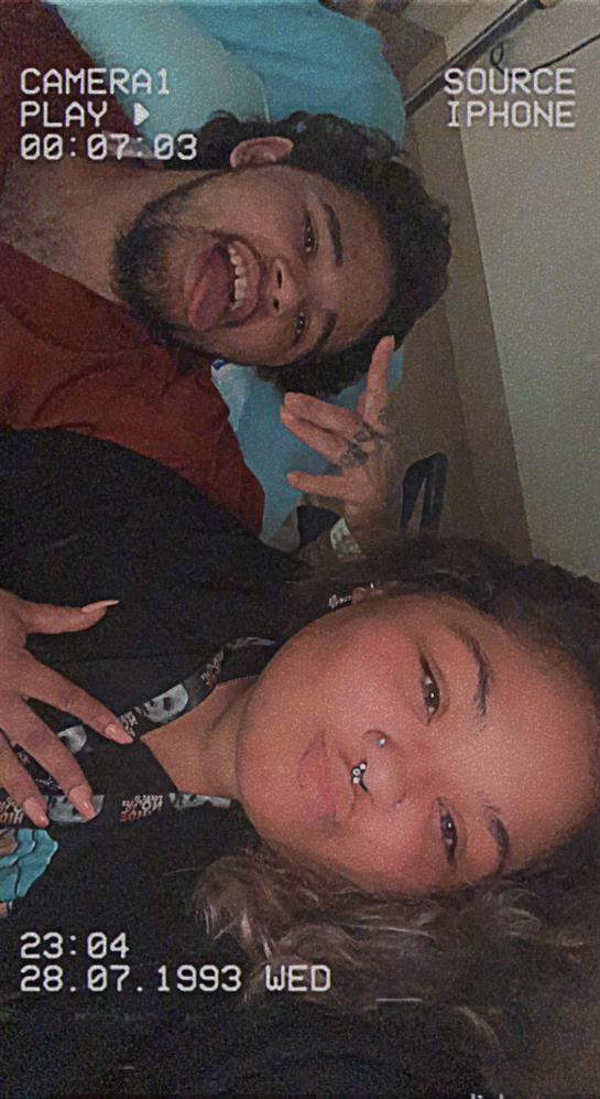 Two friends share a lighthearted moment, smiling and posing together indoors.