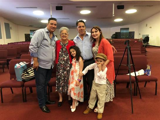 A joyful family poses together in a church hall during a special event, showcasing love and unity.