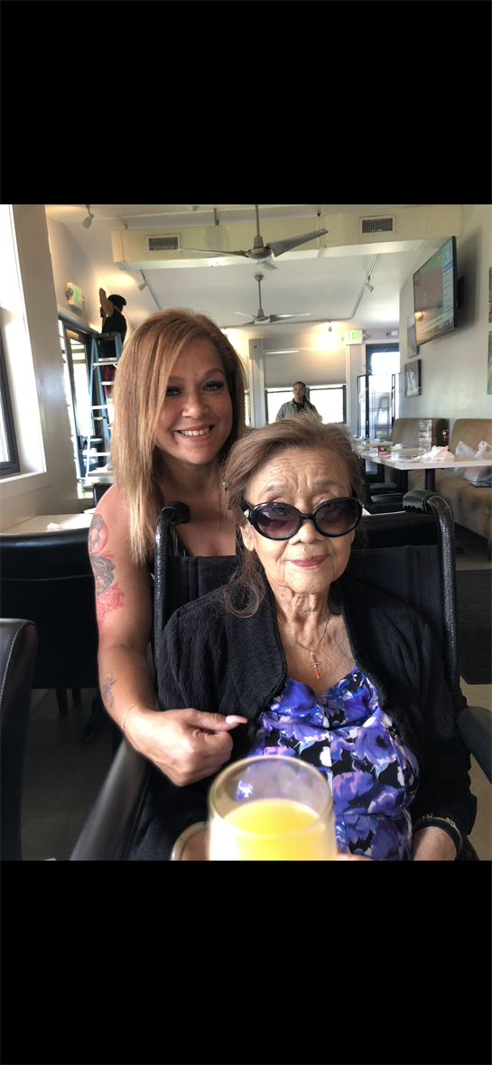 Two women share a joyful moment in a restaurant, enjoying each other's company and laughter.