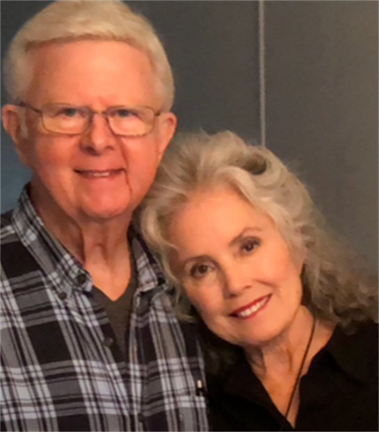 Older couple embraces warmly at home, smiling and showing affection in a cozy atmosphere.