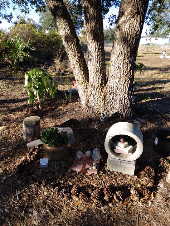 Garden area features a unique sculpture surrounded by natural elements and decorative stones.