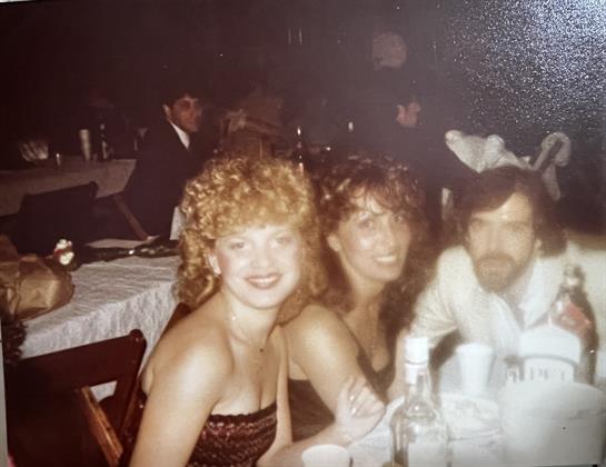 Friends enjoy a fun night out together at a restaurant, dressed up for an evening celebration.