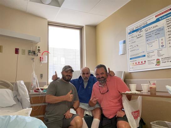 Three friends gather in a hospital room, offering support and camaraderie during recovery time.