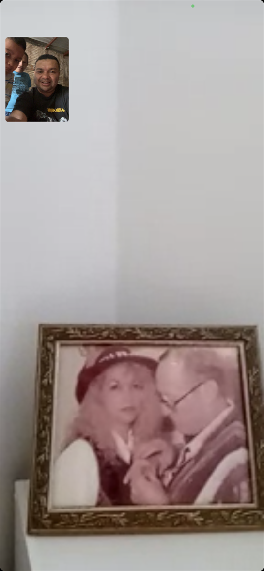 A couple is captured sharing an intimate moment, smiling at each other in a framed picture.
