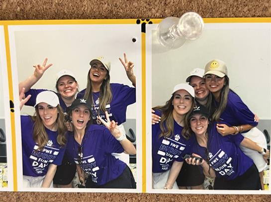 Five friends joyfully posing with smiles and peace signs in a festive environment.