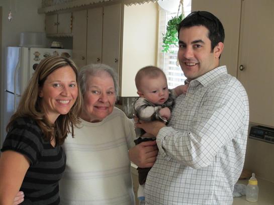 Joyful family moment with three generations in a kitchen, sharing laughter and smiles.