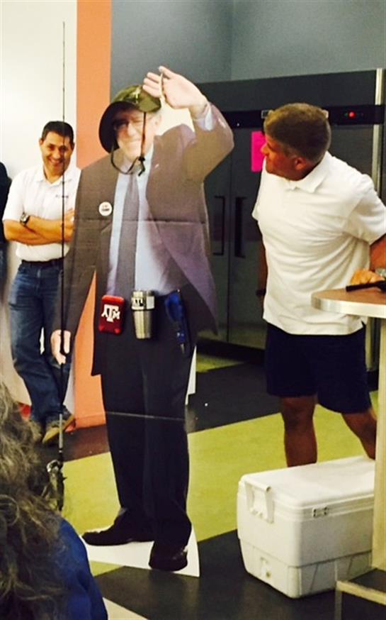 Guests interact with a life-sized standee during a lively event at a colorful venue.