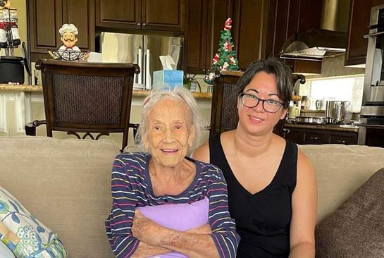 Grandmother and granddaughter relax together in a warm living space, celebrating togetherness.