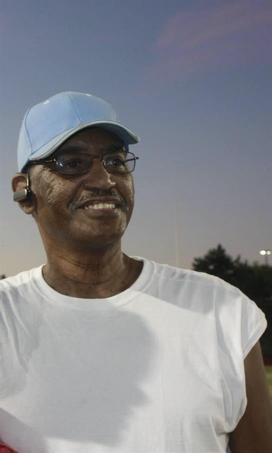 Coach encourages young athletes while enjoying the sunset at the sports field.