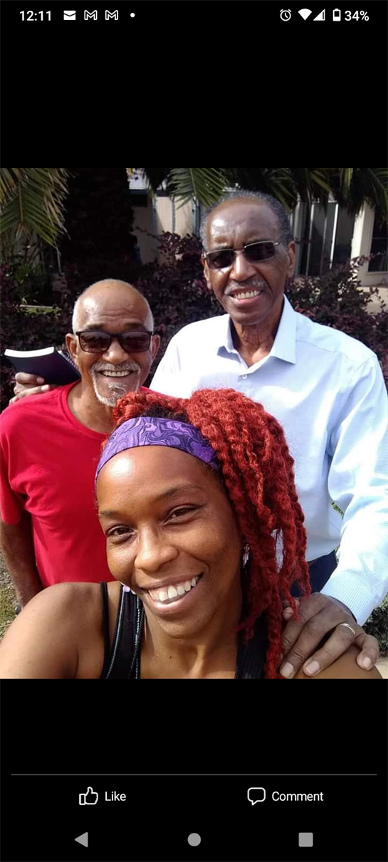 Three friends smile outdoors, relishing the warmth and each other's company.