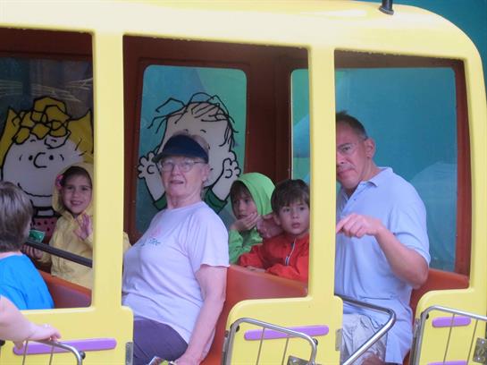 Kids and adults laugh together on a cheerful ride despite the rainy weather.