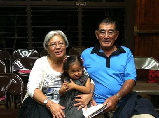 A warm and loving moment shared by grandparents and their granddaughter in a cozy room.