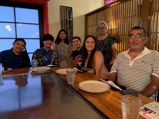 Group of people enjoying dinner together at a Japanese restaurant with a warm ambiance.