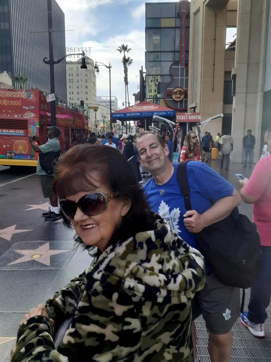 People stroll down Hollywood Boulevard, enjoying street performers and attractions.