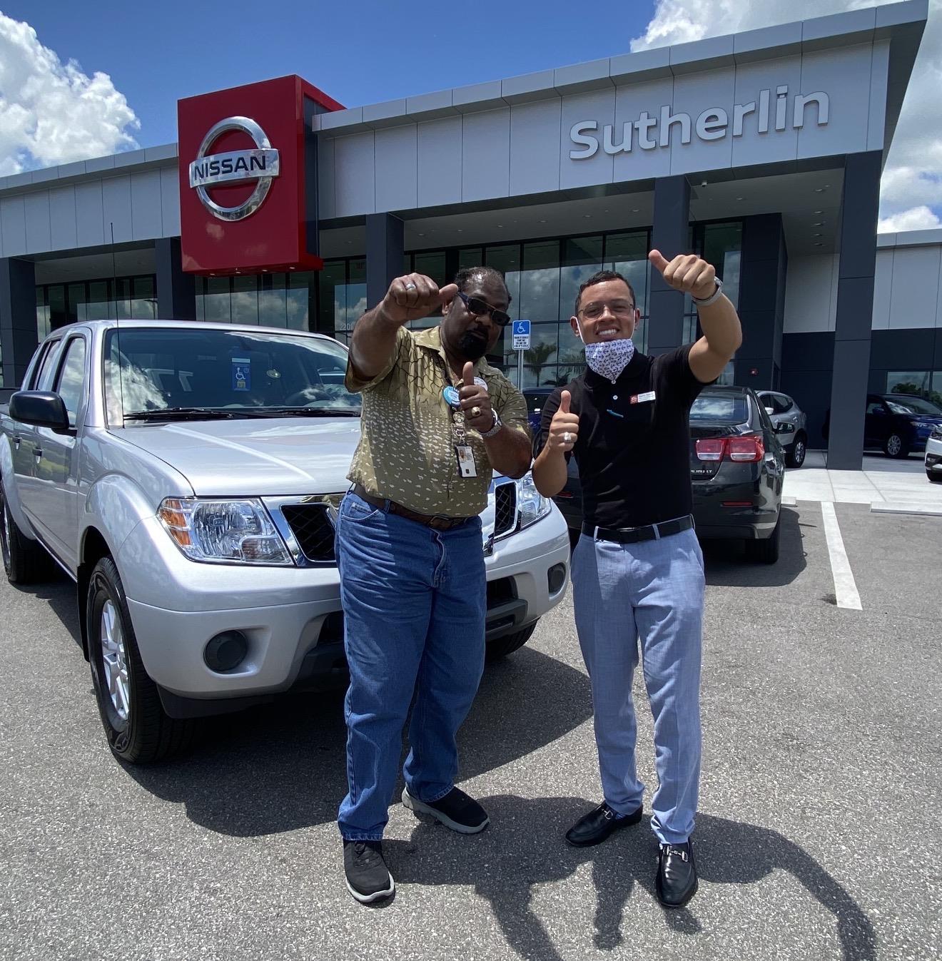 Two men standing in front of a car