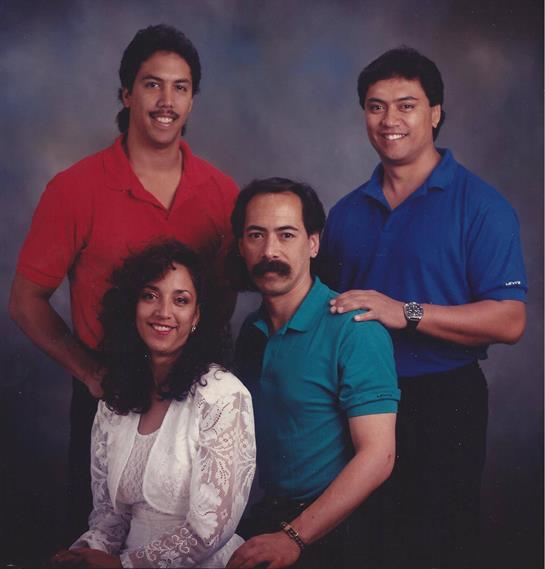 Four friends smile together in a studio, dressed in vibrant colors, showcasing camaraderie and joy.