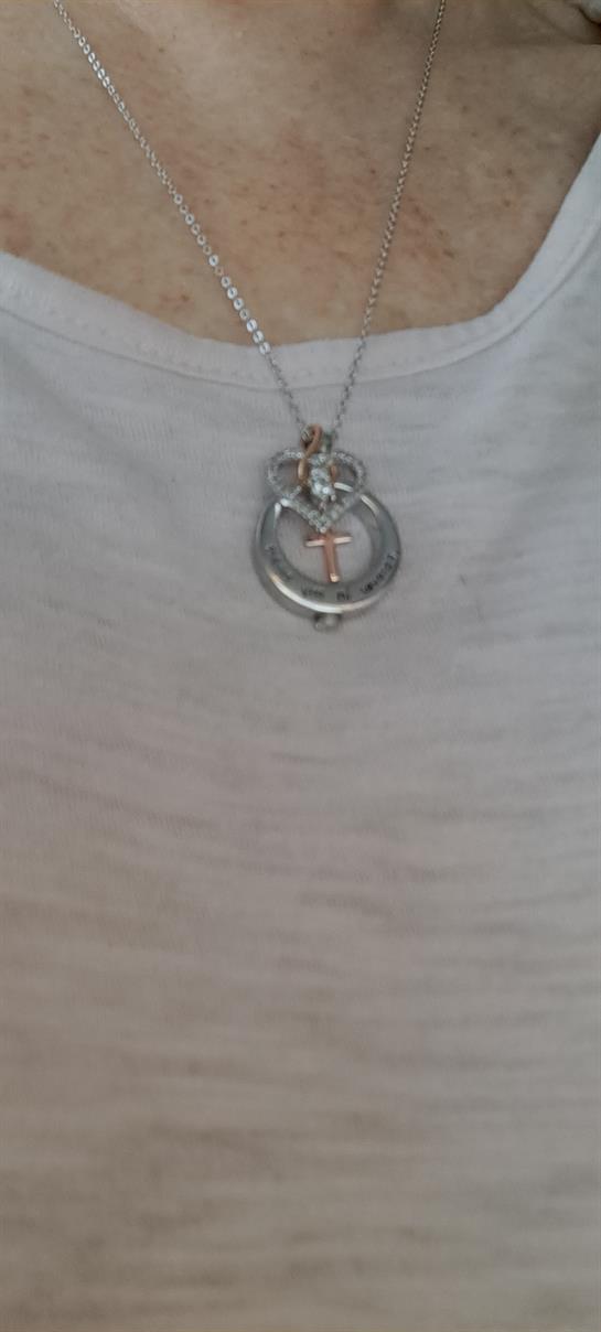 A stylish silver pendant hangs from a chain, showcasing delicate craftsmanship and artistic style.