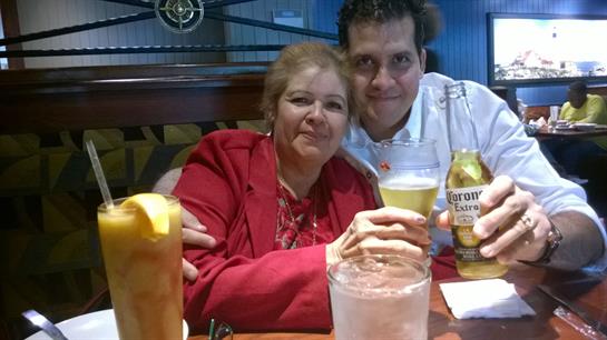 Two friends toast joyfully in a lively restaurant, sharing smiles and good times.