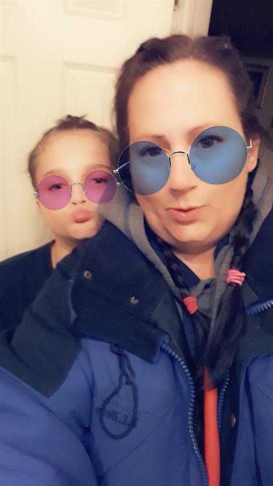 A child and adult pose together, both wearing colorful sunglasses and playful expressions.