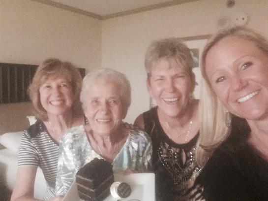 Friends share laughter and smiles while posing together in a warm, inviting room.