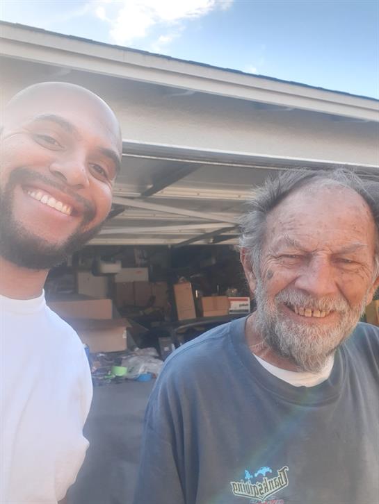 Two men share a joyful moment in a sunny garage, exuding happiness and friendship.