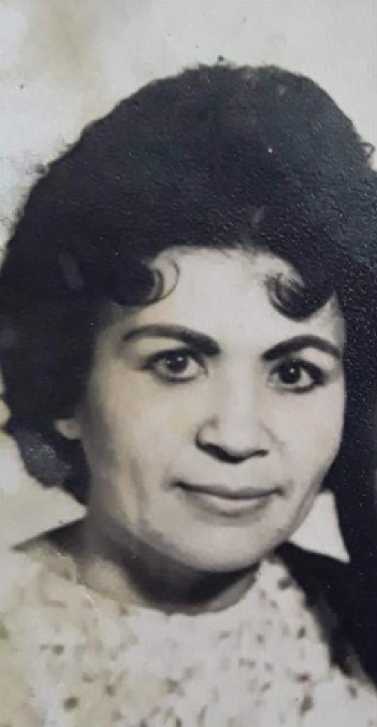 A woman with curly hair is smiling, capturing a moment of warmth and positivity in a vintage style.