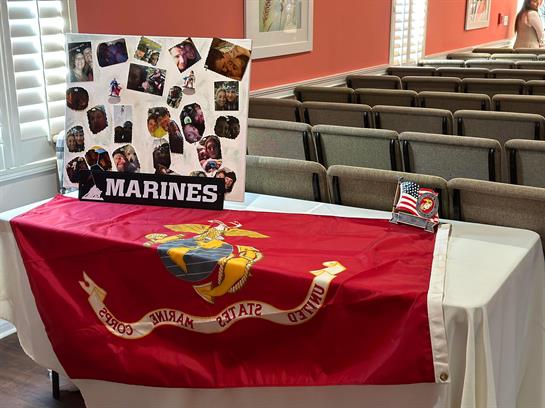 Ceremony celebrating Marines with displays, memorabilia, and a flag at a community venue.