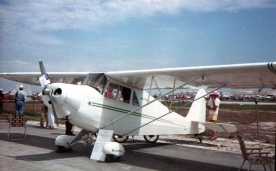 A classic biplane is parked on the runway, with a clear blue sky and enthusiastic spectators nearby.