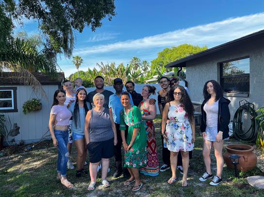 A diverse group of friends enjoys each other's company outdoors on a lively midday.