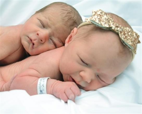 Two newborns rest together, highlighting their sibling bond in a peaceful setting.